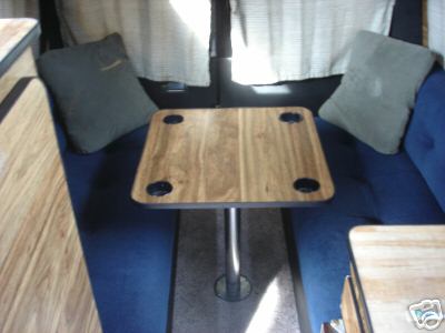 1978 Ford E250 - Interior view of a camper van, seating and a table.