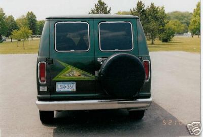 1978 Ford E250 - 1978 Ford E250 van seen from the rear, custom graphics and a spare tire. The license plate is visible.