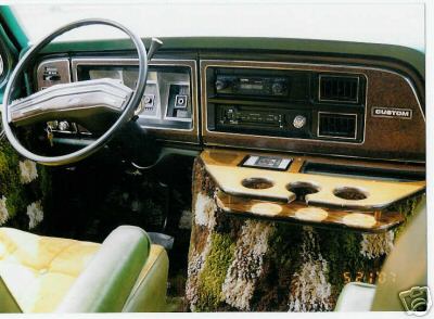 1978 Ford E250 - Scanned photo of a brown dashboard and steering wheel in a Ford van or truck cab, with a woodgrain dash applique, 'CUSTOM' badge on the rig…