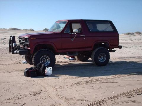 1982 Ford Bronco - This lifted 1980s Ford Bronco is shown off-road on a sandy beach with a custom front bumper.