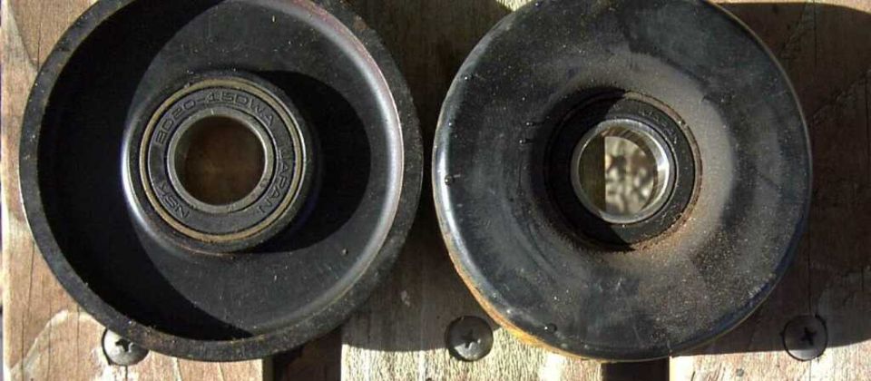Two idler pulleys, one with visible bearing markings