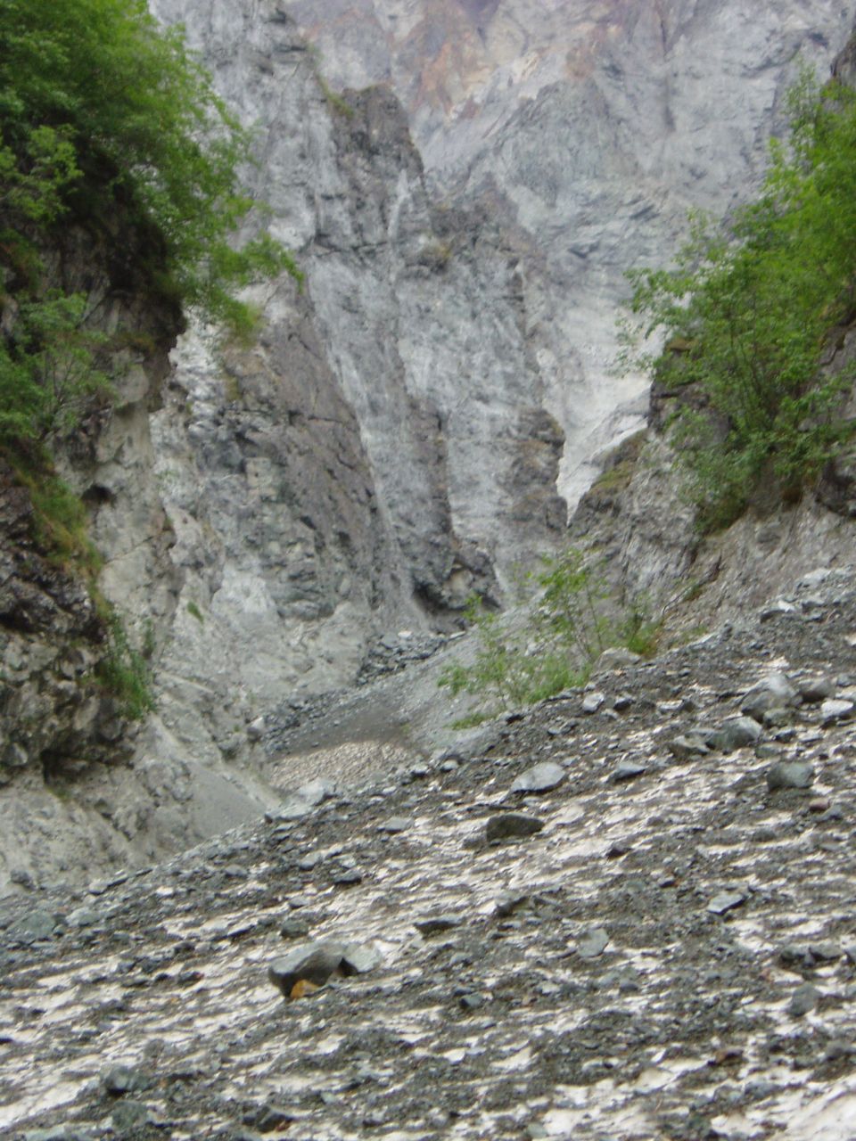 Rocky gorge with trees on the left and right, and a rocky slope in the foreground. Watermark reads www.supermotors.net