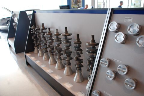 1996 Ford Bronco - A collection of engine crankshafts and pistons are displayed on shelves and a wall panel.