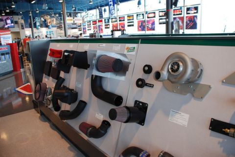 1996 Ford Bronco - Various automotive performance parts, including a turbocharger and air intake systems, are displayed for sale in a retail environment.