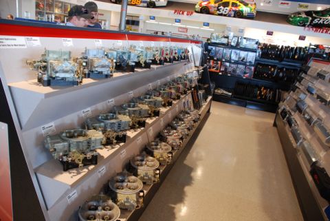 1996 Ford Bronco - A wide selection of carburetors are neatly arranged on display shelves in an automotive parts store.