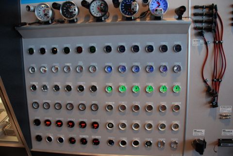 1996 Ford Bronco - A wall display features numerous automotive gauges and a set of red spark plug wires.
