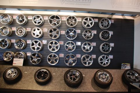 1996 Ford Bronco - A selection of aftermarket wheels and tires are displayed for sale in a retail environment.