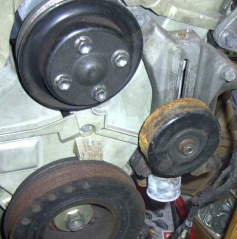 1997 Ford Taurus - Close-up of engine idler pulleys, showing signs of wear and rust.