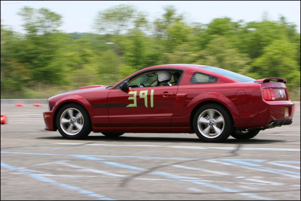 Red Ford Mustang with number 391 on the door, driving on a race track