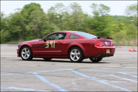 2001 Mercury Grand Marquis - Red coupe with number 391 on the side, driver wearing a helmet, on a paved track.