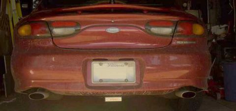 1997 Ford Taurus - Rear view of a red 1997 Ford Taurus, showing dual exhaust pipes and an Illinois license plate.