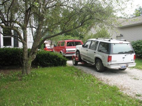 1993 Ford Explorer - A white 1995 Ford Explorer is being towed by a red truck on a gravel driveway.