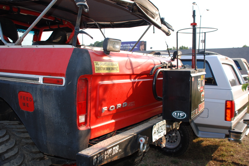 Red Ford Bronco rear with black trim, large tires, and a metal bumper