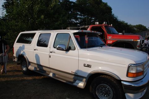 1996 Ford Bronco - This 1996 Ford Bronco is seen from the side, parked next to a red truck.