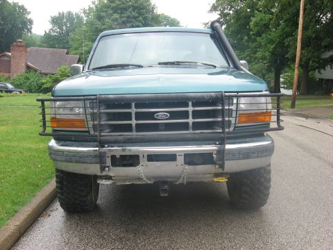 1996 Ford Bronco - This teal Ford truck is equipped with a brush guard and a snorkel intake, suggesting off-road use.