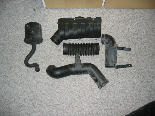 Air intake system parts laid out on carpet