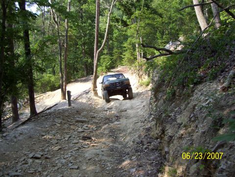 1978 Ford Bronco - A Ford Bronco navigates a challenging off-road trail with steep inclines and loose rocks.