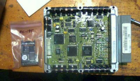 1997 Ford Taurus - An engine control module is shown next to a small chip in a plastic bag labeled PC-195.