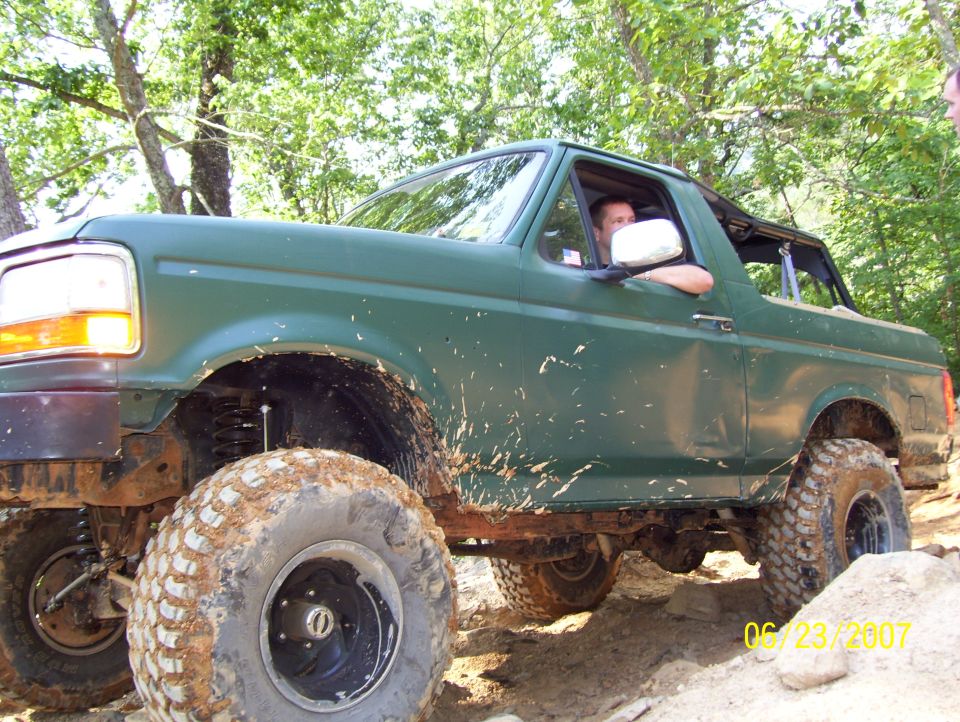 Green SUV with large off-road tires driving on a dirt trail. Date stamp reads 06/23/2007