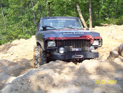 1978 Ford Bronco - A modified 1978 Ford Bronco navigates a challenging rocky trail on a sunny day.