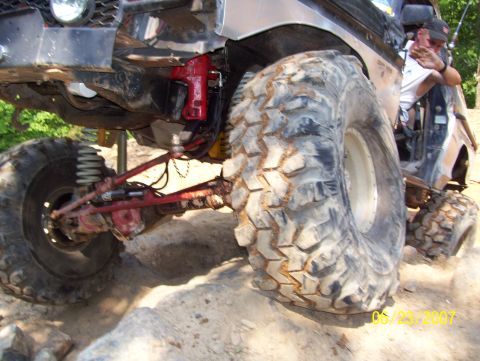 1978 Ford Bronco - A heavily modified off-road vehicle navigates rocky terrain, its large tires and suspension.