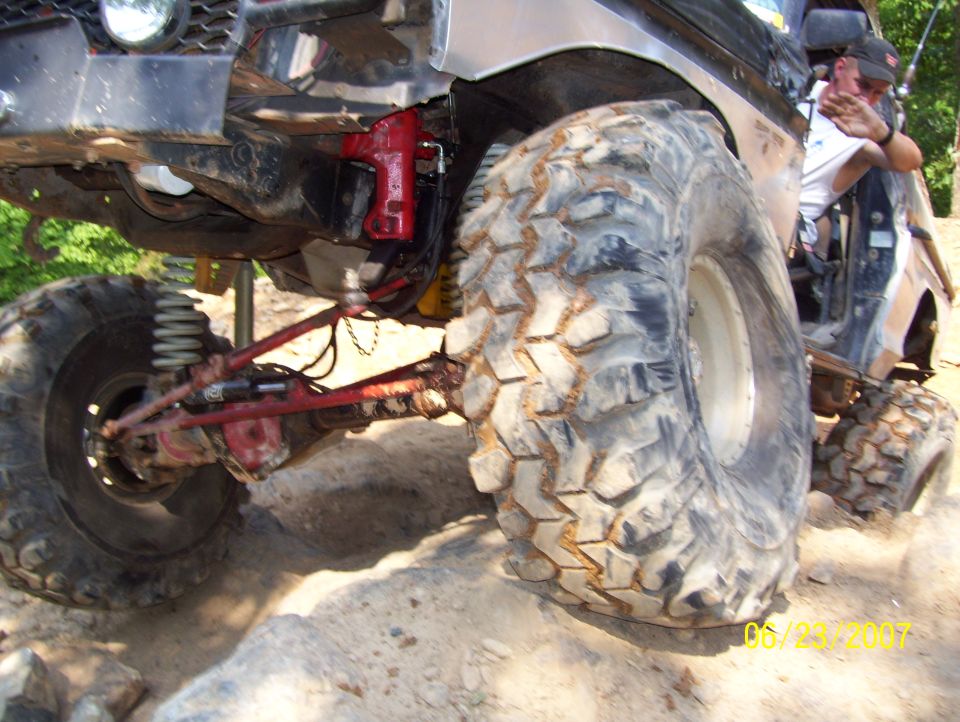 Big tires on a modified off-road vehicle, with a person in the driver's seat