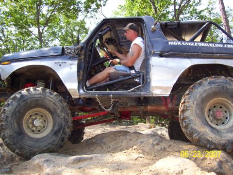 1978 Ford Bronco - Modified 1978 Ford Bronco navigates a rocky trail with a driver at the wheel.