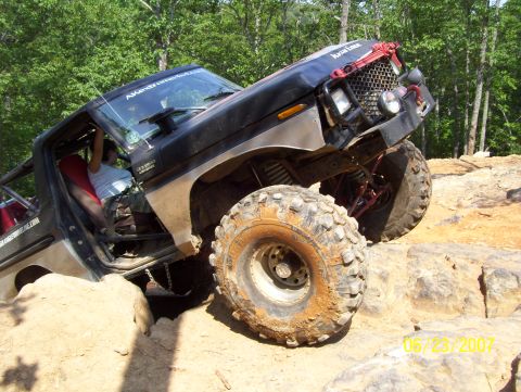1978 Ford Bronco - This heavily modified off-road vehicle navigates a rocky trail, demonstrating its extreme suspension and tire capabilities.
