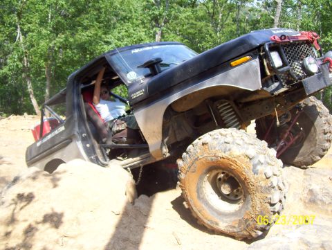 1978 Ford Bronco - 1978 Ford Bronco navigating difficult terrain with a driver inside.