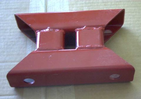 1997 Ford Taurus - A red-painted fabricated steel chassis brace lying on cardboard, made from folded sheet with two welded square tube stubs in the center and…