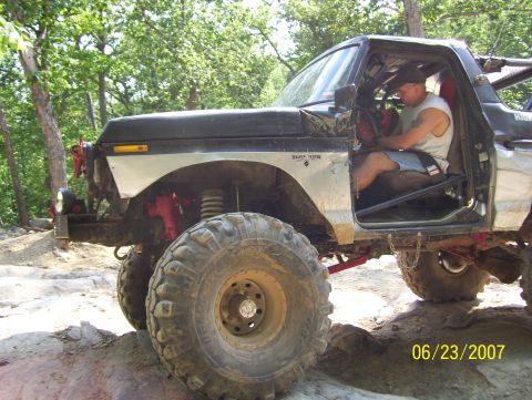 1978 Ford Bronco - Off-road 1978 Ford Bronco navigating rocky terrain with a driver inside.