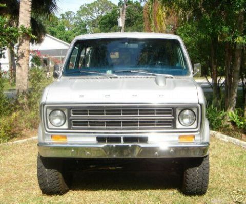 1978 Ford E250 - Head-on front view of a silver lifted Ford Econoline van with 'FORD' letters across the header panel, a horizontal-bar grille, round single…