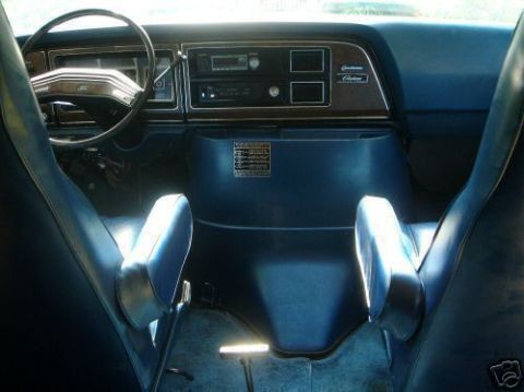 Interior view of a 1978 Ford E250 van with blue seats and dashboard