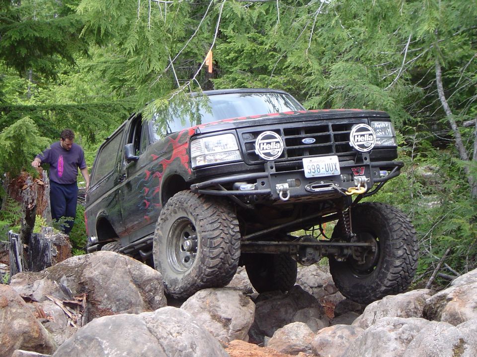 Black Ford Bronco with flames climbing rocks off-road