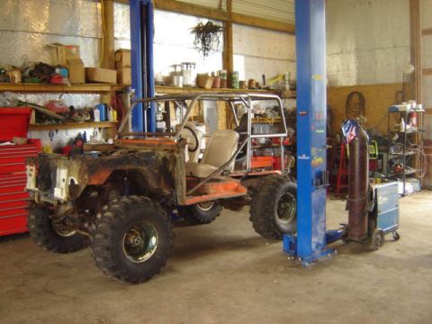 1992 Ford Bronco - Custom off-road vehicle in a workshop, missing its front body panels and hood.