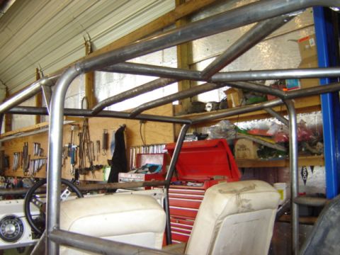 1992 Ford Bronco - Custom roll cage construction in progress inside a workshop, showing metal tubing and interior components.