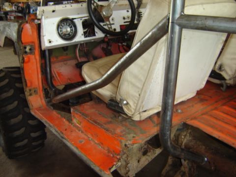 1992 Ford Bronco - The interior of a vintage Ford Bronco, a roll cage and worn seats, suggests a project vehicle.