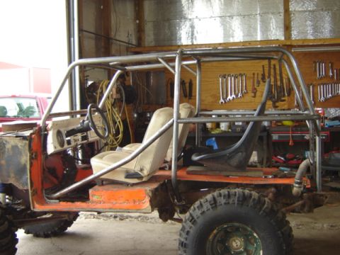 1992 Ford Bronco - This vehicle appears to be a heavily modified off-road build, possibly a Ford Bronco, with extensive roll cage and custom interior.