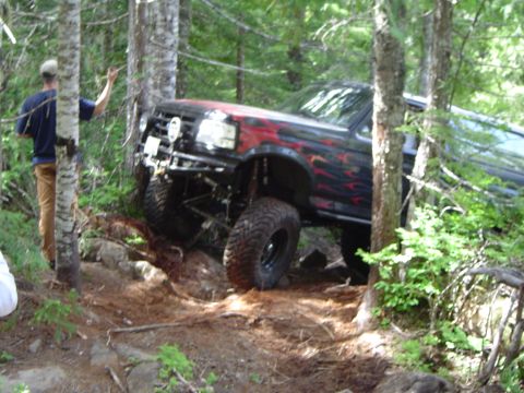 1989 Ford Bronco - A modified Ford Bronco navigates a rocky, wooded trail.