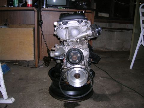 1992 Nissan 240SX - Engine assembly resting on a tire rim, likely for repair or replacement.