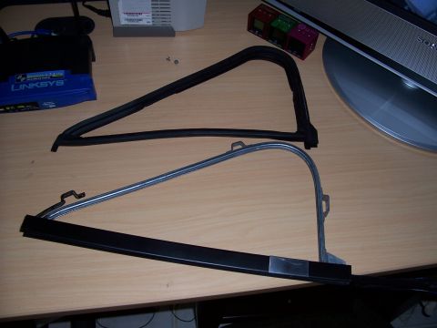 1978 Ford Bronco - Automotive window trim parts are laid out on a desk, with a computer monitor and networking equipment in the background.