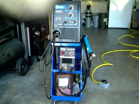 1989 Ford Bronco - Welding and plasma cutting equipment shown on a cart in a garage setting.