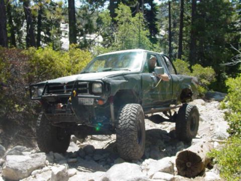 1986 Ford Bronco - This modified truck is shown off-roading on a sunny day.
