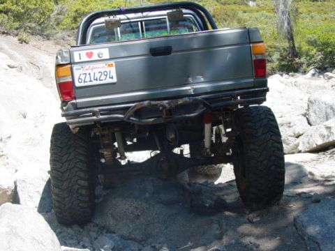 1986 Ford Bronco - This lifted SUV navigates rocky terrain, its rear end prominently displayed with a California license plate.