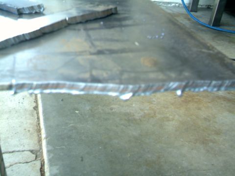1989 Ford Bronco - Metal pieces that have been cut, resting on a workbench.