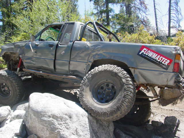 Gray pickup truck with off-road modifications on rocks