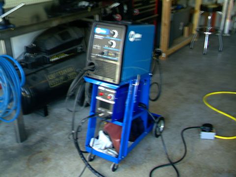 1989 Ford Bronco - Welding equipment including a Miller machine and a Craftsman air compressor are shown in a garage setting.