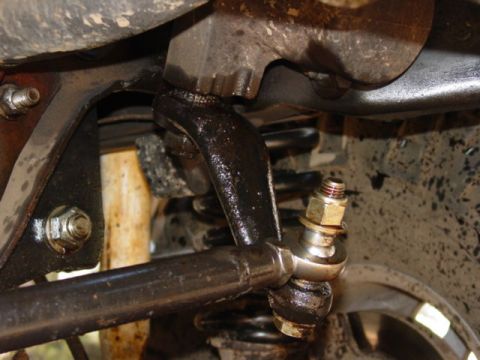 1986 Ford Bronco - Underside view of a vehicle's steering and suspension system, showing various greasy components and a shock absorber.