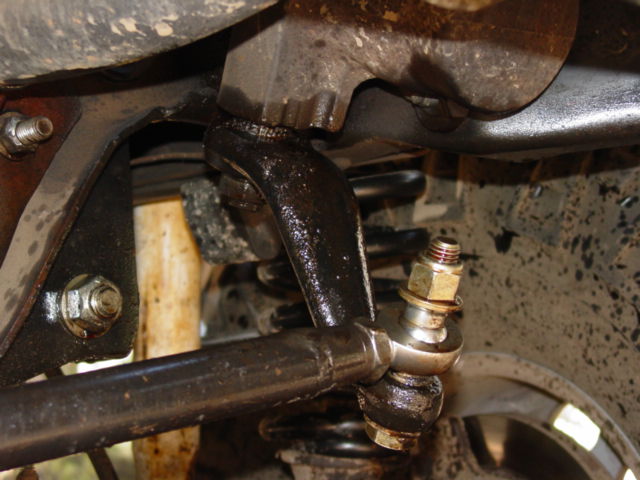 Close-up of greasy steering linkage and suspension parts on a vehicle
