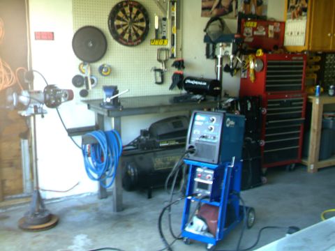 1989 Ford Bronco - A workshop scene a welding machine, air compressor, and various tools on a workbench.